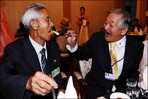 추석 계기 이산가족상봉 행사 첫날인 26일 오후 금강산호텔에서 열린 환영만찬에서  남측 상봉자인 이정호 씨(오른쪽)가 국군포로 형인 북측 리쾌석 씨에게 음식을 먹여주고 있다.