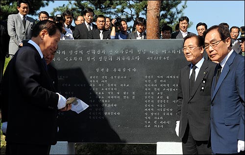  6일 국립서울현충원에서 거행된 고 김대중 전 대통령 묘비 및 추모비 제막식에서 정,관계인사들이 고은 시인의 추모시 "당신은 우리입니다"를 새겨 넣은 추모비를 살펴보고 있다.