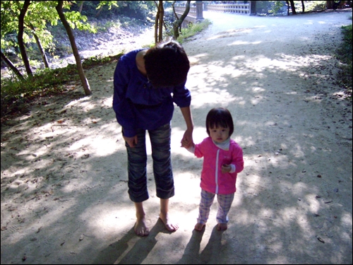 엄마 손을 잡고 맨발로 골짜기 길을 걷는 예쁘고 귀여운 아기