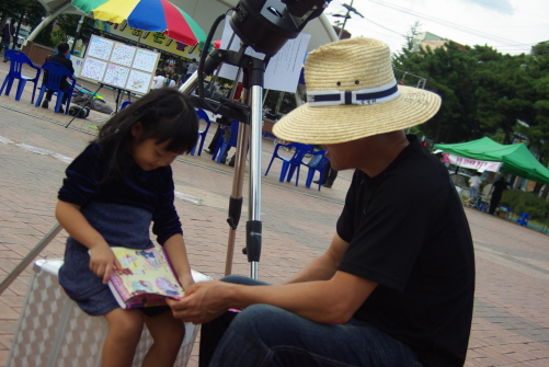 김성태씨는 녹색장터에 온 아이와 함께 책을 보고 있다. 