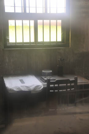창밖에서 들여다 본 감방 내부로, 침대는 물론 의자와 책상, 먹, 붓 등이 놓여 있다.