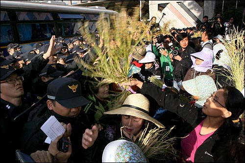 지난 10월 20일 오후 여의도 국회앞에서 열린 '쌀값 폭락 해결과 대북쌀지원 법제화 촉구를 위한 전국여성농민대표자대회'에 참석한 여성농민들이 국회로 행진을 벌이다 경찰에 막히자 볏단을 휘두르며 항의하고 있다.