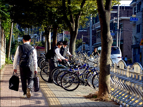 학교 앞 자전거 거치대에서 자전거 찾아 친구와 함께 돌아가는 학생들