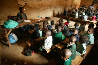 케냐 나이로비 키베라에서 비공식으로 운영되는 성 콜린 초등학교 수업광경. 학비를 부담할 수 없는 가난한 이 지역 어린이들이 진흙으로 지은 임시건물 안에서 벤치처럼 긴 의자에 붙어앉아 책상도 없이 공부하고 있다. 