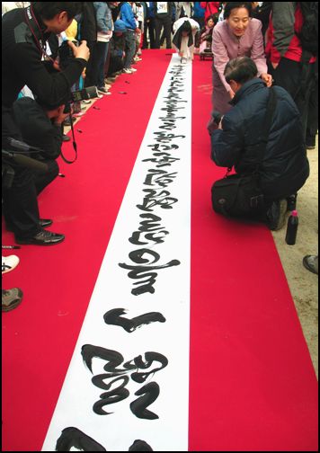 서예가 공재 김 일명 선생께서 10여m 길이의 걸개에 "남북통일을 염원"하는 글을 현장 휘호하고 계신 모습