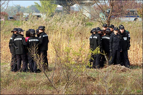  양평군 양수리 두물머리 마을에서 경찰이 대거 동원된 가운데 '4대강 사업' 예정지에 대한 측량 작업이 강행되고 있다. 경찰들이 측량작업에 항의하는 농민들을 한명씩 에워싸고 있다.