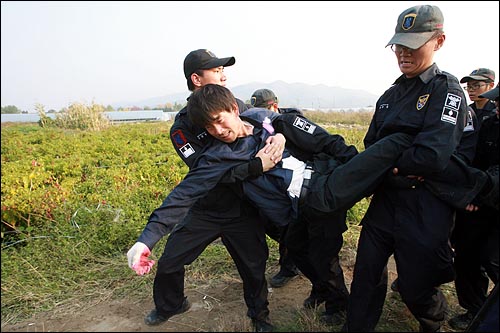 26일 오후 경기도 남양주시 양수리 두물머리 마을에서 '4대강 사업' 예정지에 대한 측량 작업이 강행된 가운데, 경찰들이 측량작업에 항의하는 농민, 환경단체 회원들을 강제연행하고 있다.