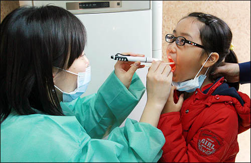 서울의 한 병원에서 한 의사가 신종플루 감염이 의심되는 아이를 진찰하고 있다. 