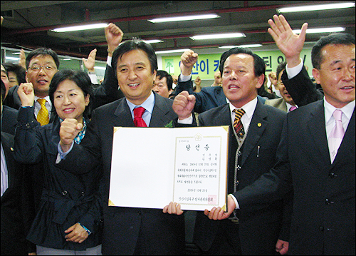 선관위로 부터 당선증을 받은 김영환 당선자가 지지자들과 함께 구호를 외치고 있다