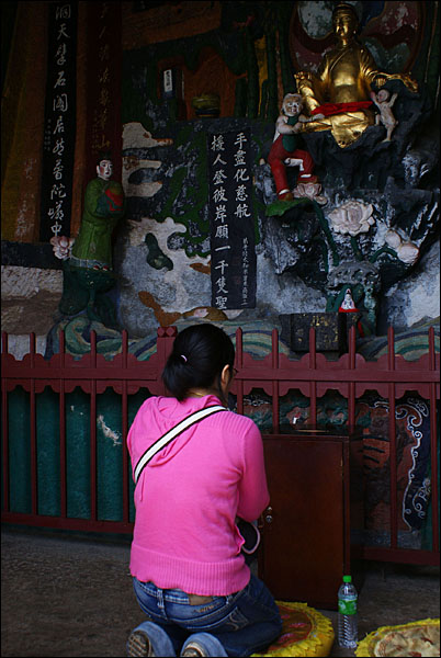 룽먼석굴은 도교사원이다. 다톈거의 신선상 앞에서 절을 드리는 한 젊은 여성.
