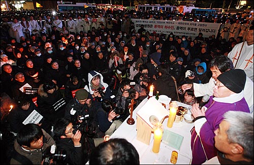 전종훈 천주교정의구현전국사제단 신부가 2일 밤 서울광장에서 열린 '죽은 자들과 죽어가는 뭇 생명들을 위한 위령미사'에서 경찰에 둘러싸인 채 수녀와 신자들과 함께 시국미사를 봉헌하고 있다.