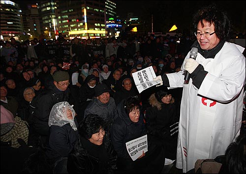 김인국 천주교정의구현전국사제단 신부가 2일 밤 서울광장에서 열린 '죽은 자들과 죽어가는 뭇 생명들을 위한 위령미사'에서 경찰에 둘러싸인 채 수녀와 신자들과 함께 시국미사를 봉헌하고 있다.
