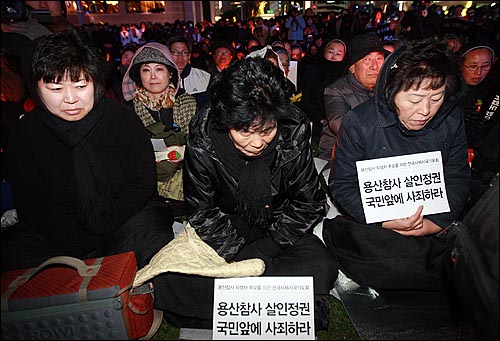 용산참사 유가족들과 성직자, 시민들이 2일 밤 서울광장에서 열린 '죽은 자들과 죽어가는 뭇 생명들을 위한 위령미사'에서 경찰에 둘러싸인 채 용산참사 희생자들의 넋을 기리며 시국미사를 드리고 있다.