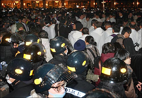 천주교정의구현전국사제단 신부들이 2일 밤 서울광장에서 열린 '죽은 자들과 죽어가는 뭇 생명들을 위한 위령미사'에서 경찰에 둘러싸인 채 용산참사 해결을 촉구하고 있다.