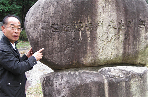  창원시 마산합포구 현동에 있는 장지연 묘소를 경상남도 문화재 지정에서 해제해야 한다는 목소리가 높다. 사진은 김영만 Corea평화연대 상임대표가 장지연 묘소의 표지석을 둘러보고 있는 모습.