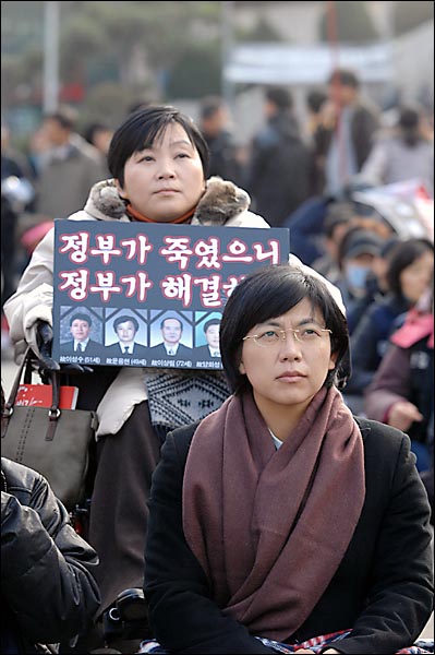  민주노동당 이정희 의원이 14일 오후 서울역 광장에서 개최된 '용산참사 300일 범국민 추모대회'에 참석한채 무대쪽을 응시하고 있다.