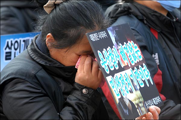 용산참사가 일어난지 300일을 하루앞둔  14일 오후 서울역 광장에서 개최된 '용산참사 300일 범국민 추모대회'에서 한 참가자가 눈물을 닦아내고 있다.