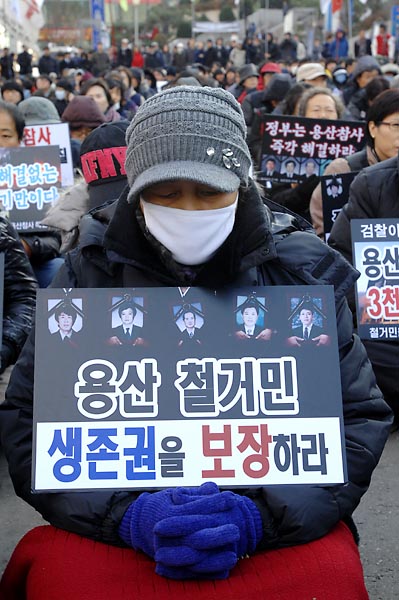 용산참사가 일어난지 300일을 하루앞둔  14일 오후 서울역 광장에서 개최된 '용산참사 300일 범국민 추모대회'에서 한 참가자가 두손을 모은채 눈을 감고 있다.