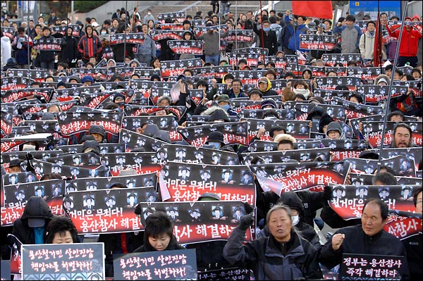 용산참사가 일어난지 300일을 하루앞둔  14일 오후 서울역 광장에서 개최된 '용산참사 300일 범국민 추모대회'에서 참가자가 '용산참사 해결'을 촉구하며 구호를 외치고 있다.
