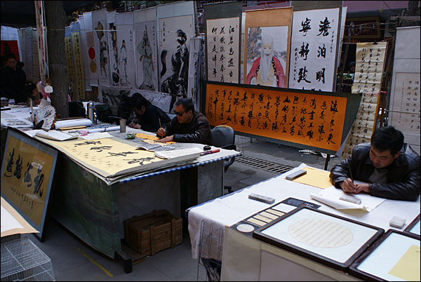 수위안먼의 노점에서 서예를 쓰고 그림을 그리는 상인들. 수위안먼의 상인은 장사꾼이자 예술가다.
