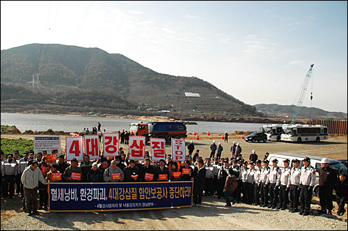 농민.환경단체는 20일 오전 4대강정비사업의 낙동강 18공구 함안보 공사 현장 입구에 경찰에 에워싸여 기자회견을 열었다.