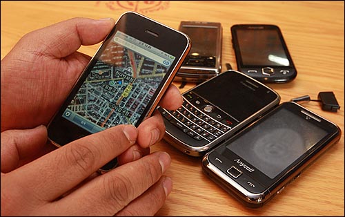 국내 아이폰 개통 1호 사용자 이성진씨가 자신의 아이폰을 단말기와 옴니아1, 블랙베리, 햅틱아몰레드, 터치다이아몬드 단말기를 비교해 보이고 있다.
