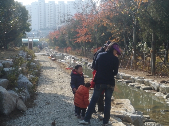 한 가족이 나들이를 나와서 생태하천 맑은 물을 바라보고 있다.

 


