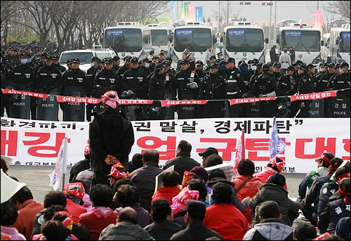 기공식장 부근에서 '4대강 사업 중단'을 촉구하는 시민사회단체의 집회가 열리는 가운데 경찰버스와 병력이 기공식장으로 향하는 도로를 차단하고 있다.