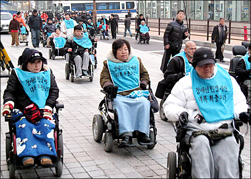 세계 장애인의 날을 하루 앞둔 2일 장애인 단체 회원들 수십명이 국회 앞 한나라당사 주변을 행진하며 장애인 예산 확대를 촉구하고 있다.