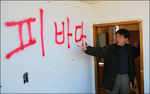 서울 동대문구 전농·답십리뉴타운 내 전농7구역 세입자 이정열(40)씨가 '피바다'라고 쓰인 한 공가의 벽면을 가리키고 있다.