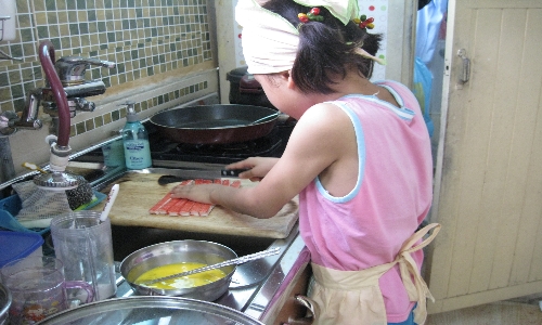 딸 서헌이가 게맛살에 달걀을 입혀 엄마와 아빠를 위해 반찬을 준비하고 있다.