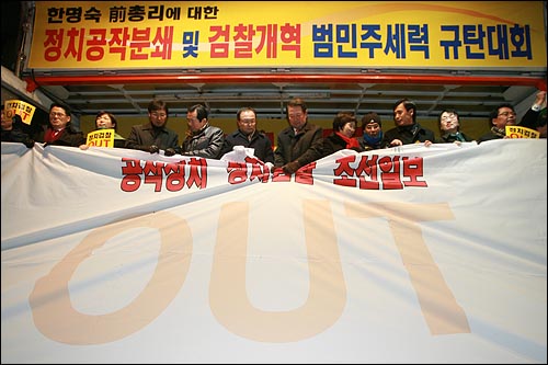 15일 저녁 서울 명동에서 열린 '한명숙 전 총리에 대한 정치공작분쇄 및 검찰개혁 범민주세력 규탄대회'에서 참석자들이 '공작정치 정치검찰 조선일보'가 적힌 천을 찢고 있다.