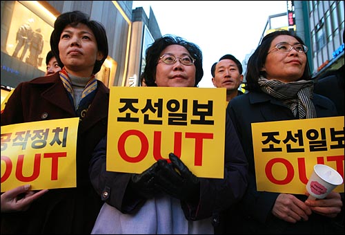 '한명숙 전 총리에 대한 정치공작분쇄 및 검찰개혁 범민주세력 규탄대회'에서 참석자들이 '공작정치 아웃'  '조선일보 아웃'이 적힌 손피켓을 들고 있다.