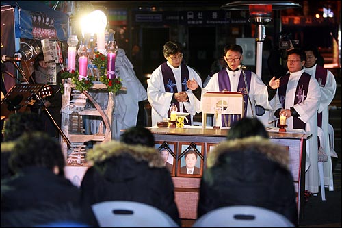 용산철거민참사가 발생한지 337일째를 맞이한 22일 저녁 서울 한강로 남일당 빌딩앞에서 유가족과 시민들이 참석한 가운데 천주교정의구현사제단 생명평화미사가 열리고 있다.