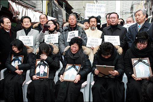30일 낮 용산구 남일당건물앞에서 열린 '용산참사 협상타결' 발표 범대위 기자회견에서 사망한 남편의 영정사진을 껴안고 있는 유가족들이 오열하고 있다.