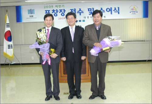 대전 중구의회 김경훈(왼쪽)의원이 대전지검장으로 부터 '포창장'을 받고 기념촬영을 하고 있다.