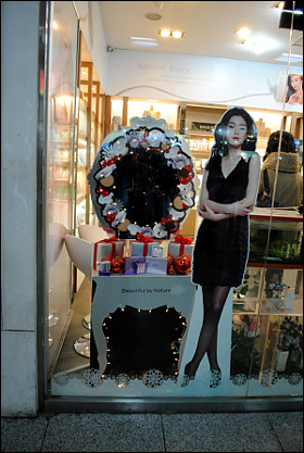 화장품 브랜드숍 진열장에 놓여 있는 배우 전지현의 전신 사진