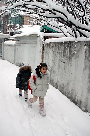 4일 새벽부터 서울 시내에 폭설이 내리는 가운데 성북구 하월곡동에서 어린이들이 눈 쌓인 골목길을 종종걸음으로 가고 있다.
