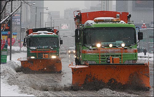4일 오후 서울 광화문광장 도로에서 제설차량이 쌓인 눈을 치우고 있다.