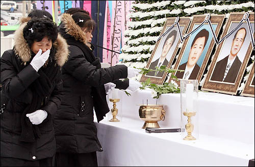 용산참사 희생자 유족들이 9일 오후 서울역광장에서 열린 영결식에서 고인들의 영정에 헌화하고 있다.