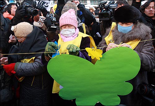 13일 정오 서울 종로구 주한일본대사관 앞에서 열린 900회 수요집회에서 위안부 할머니들과 여성단체 참가자들이 일본군 위안부 강제동원 문제해결을 촉구하는 글을 나비 모양의 종이에 적어 끈에 매달고 있다.