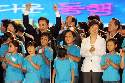 2007년 8월 20일 한나라당 전당대회에서 제17대 대통령 후보로 선출된 이명박 후보가 '아름다운 동행'이라고 적힌 현수막 앞에서 어린이합창단과 함께 노래를 부른 뒤 당원들 앞에서 대선승리를 다짐하고 있다.