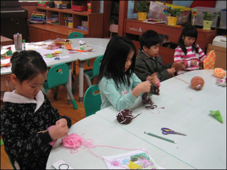 뜨개질을 하고 있는 방과 후 교실 아이들의 모습입니다.