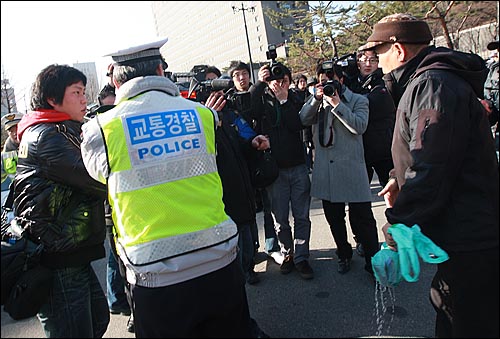 21일 오후 서초동 서울중앙지법 앞에서 열린 '이용훈 대법원장과 문성관 판사 사퇴 촉구 기자회견' 중 한 보수단체 회원이 취재를 하고 있던 MBC 카메라 기자에게 휘발유를 뿌리고 있다.