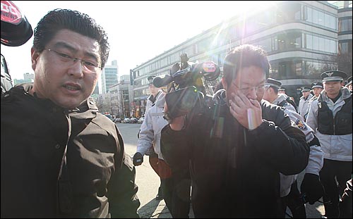 MBC 카메라 기자가 보수단체 회원이 뿌린 휘발유를 닦아내고 있다.