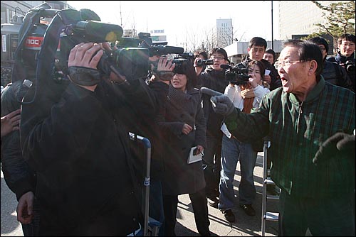 보수단체 회원들이 MBC 'PD수첩' 무죄판결에 항의하며 MBC 카메라 기자에게 욕설을 퍼붓고 있다.