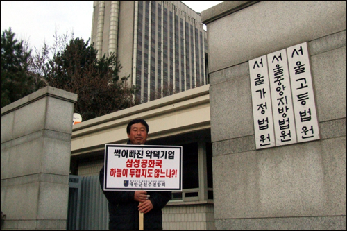 지난해 12월 15일 서울고등법원에서 열린 삼성중공업 책임제한 재판의 판결문이 각하 결정이 내려진 채 22일 항고인들에게 도착했다. 사진은 지난달 15일 재판이 열린 고등법원 앞에서 피켓시위를 벌이고 있는 피해민의 모습.