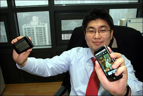 국내 구글폰 넥서스원 첫 개통자인 강훈구 지니 대표가 오른손에 아이폰을, 왼손에 구글 넥서스원을 들고 있다.