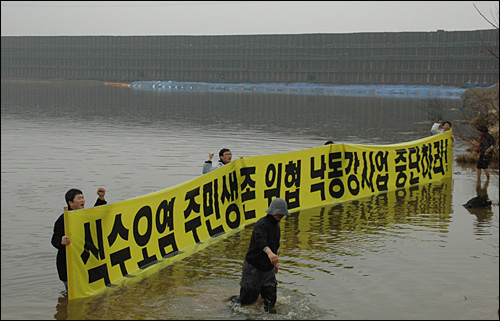 낙동강국민연대는 9일 오후 함안보 공사장 바로 아래 낙동강에 들어가 4대강사업 중단을 촉구하는 구호를 외쳤다.