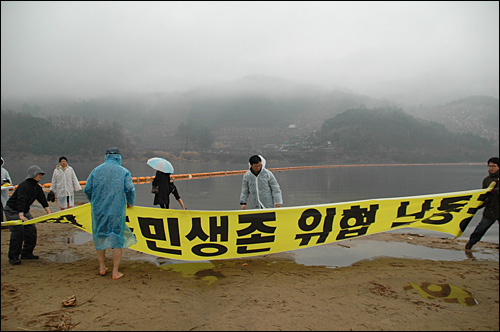 활동가들이 9일 오후 함안보 공사현장 아래 낙동강에서 대형펼침막을 들고 시위를 벌이고 있다.